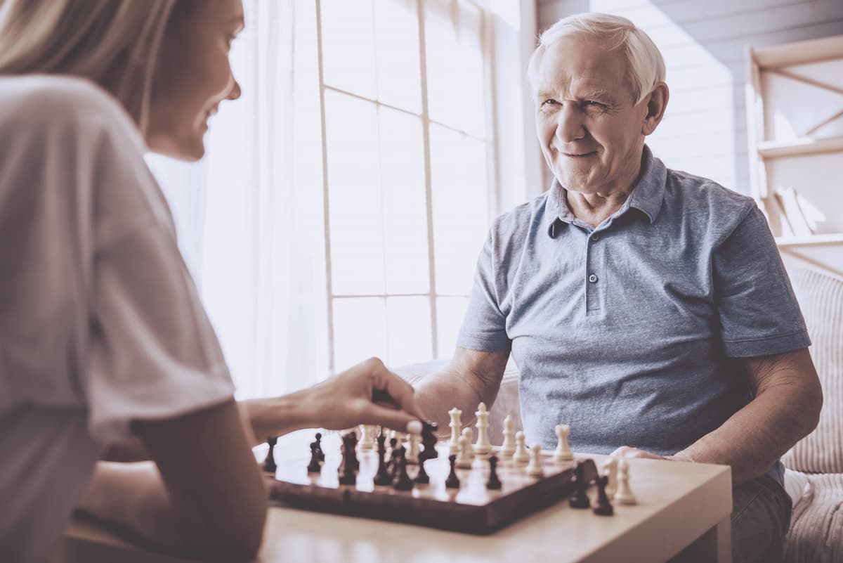 Tucson Place at Ventana Canyon | Senior man playing chess with caregiver