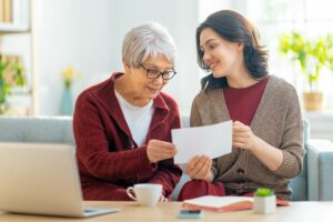 Tucson Place at Ventana Canyon | Senior woman looking at photos with caregiver