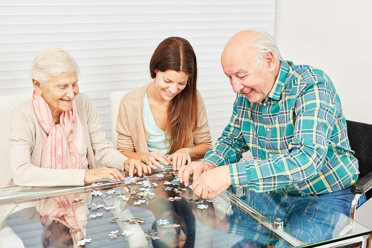 Whispering Winds of Apple Valley | Senior couple and adult daughter working on puzzle