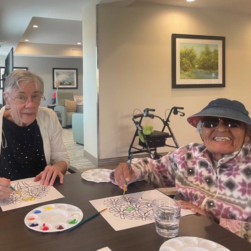 Whispering Winds of Apple Valley | Seniors smiling while painting