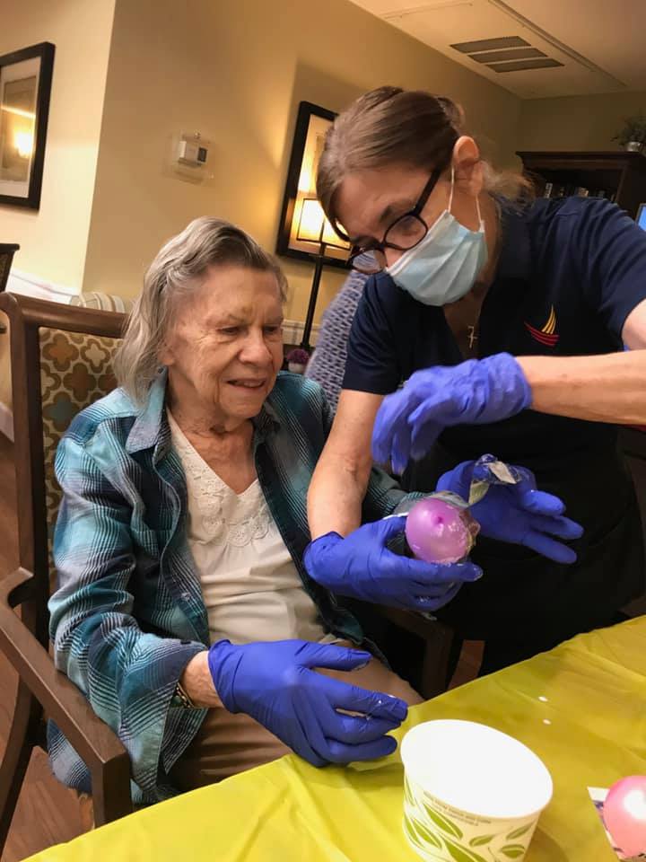 Pegasus Senior Living | Associate helping resident with craft