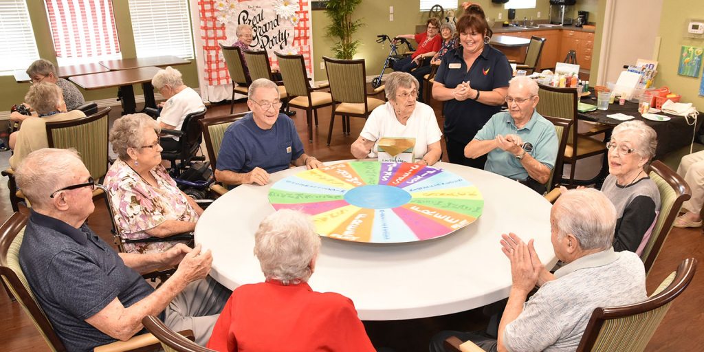 Pegasus Senior Living | Teresa Hadley, Life Enrichment Director, leads a group of residents in a game at Broadway Mesa Village, Mesa, AZ