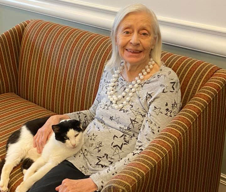 Pegasus Senior Living | Resident at The Farrington at Tanglewood petting foster cat in Houston, TX
