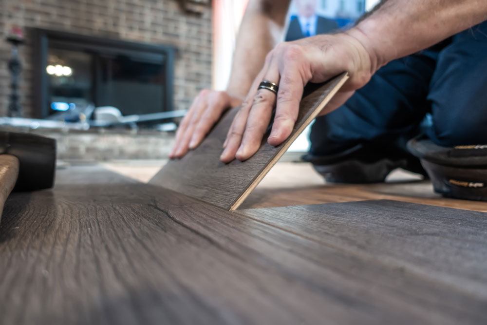 Pegasus Senior Living | Man installing vinyl plank flooring at a senior living community