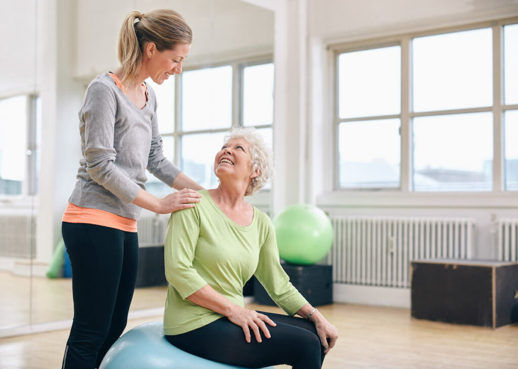 Pegasus Senior Living | Caregiver Assisting Senior with Exercise Activities