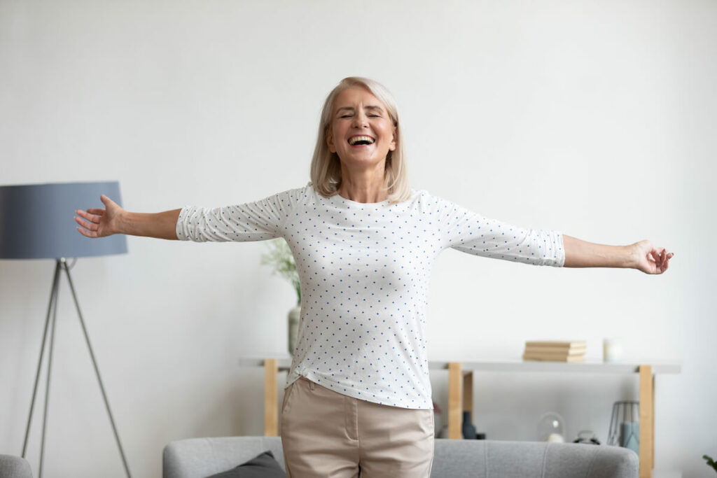 Pegasus Senior Living | Independent senior smiling with her arms wide open