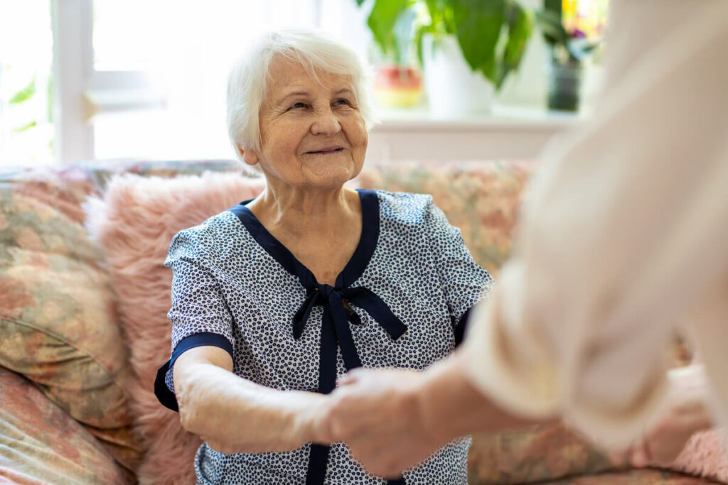 Pegasus Senior Living | Senior woman smiling and holding her caregivers hands