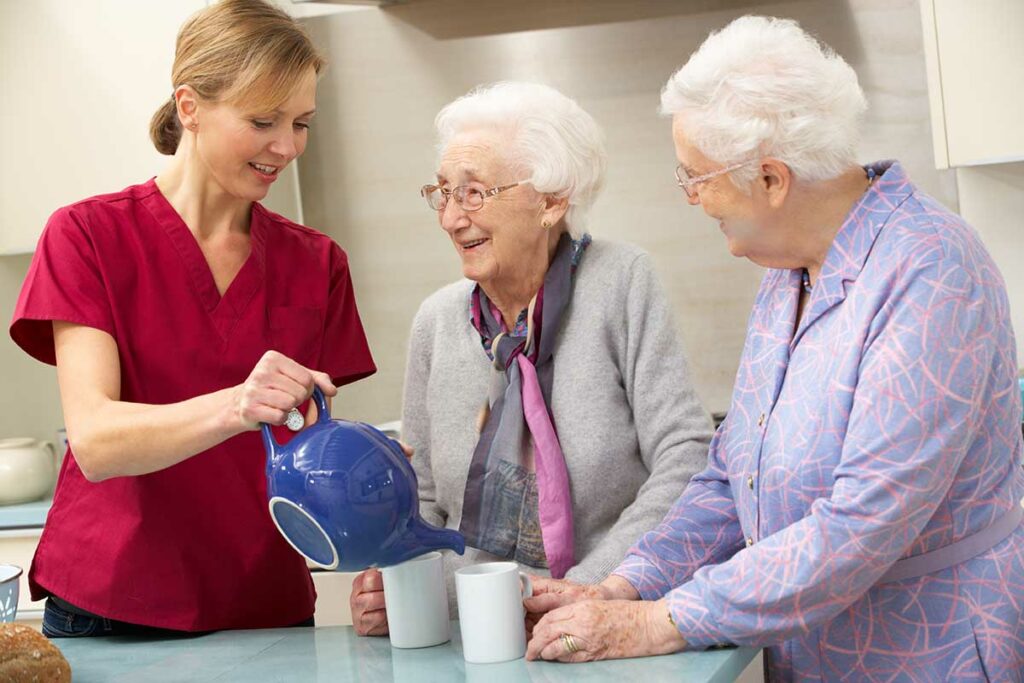 The Courtyards at Mountainview | Senior women at home with carer pouring tea