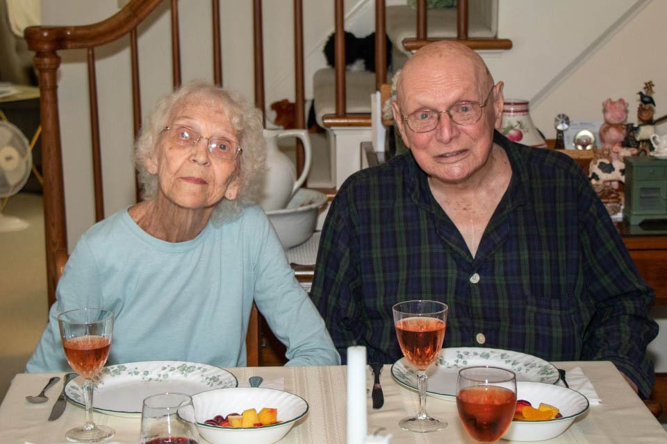 Evergreen Place | Senior couple sitting at dinner table celebrating their anniversary