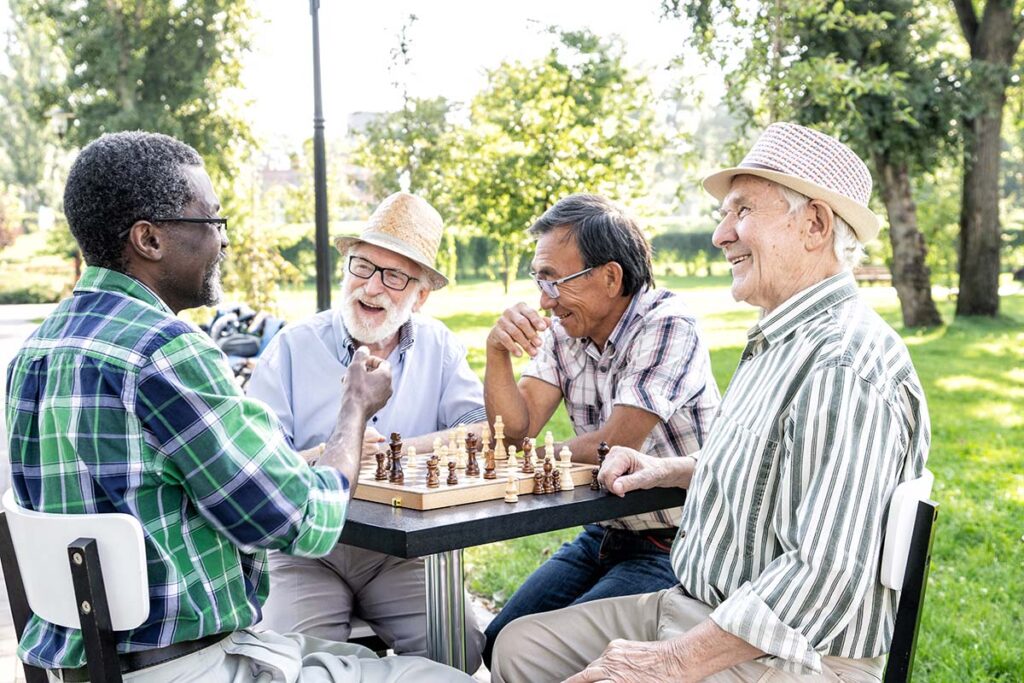 North Point Village | Group of senior friends playing chess game at the park