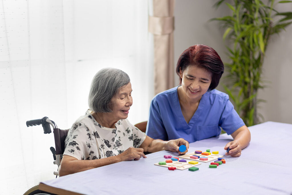 Belleview Suites at DTC | Caregiver and senior woman playing wooden shape puzzles game