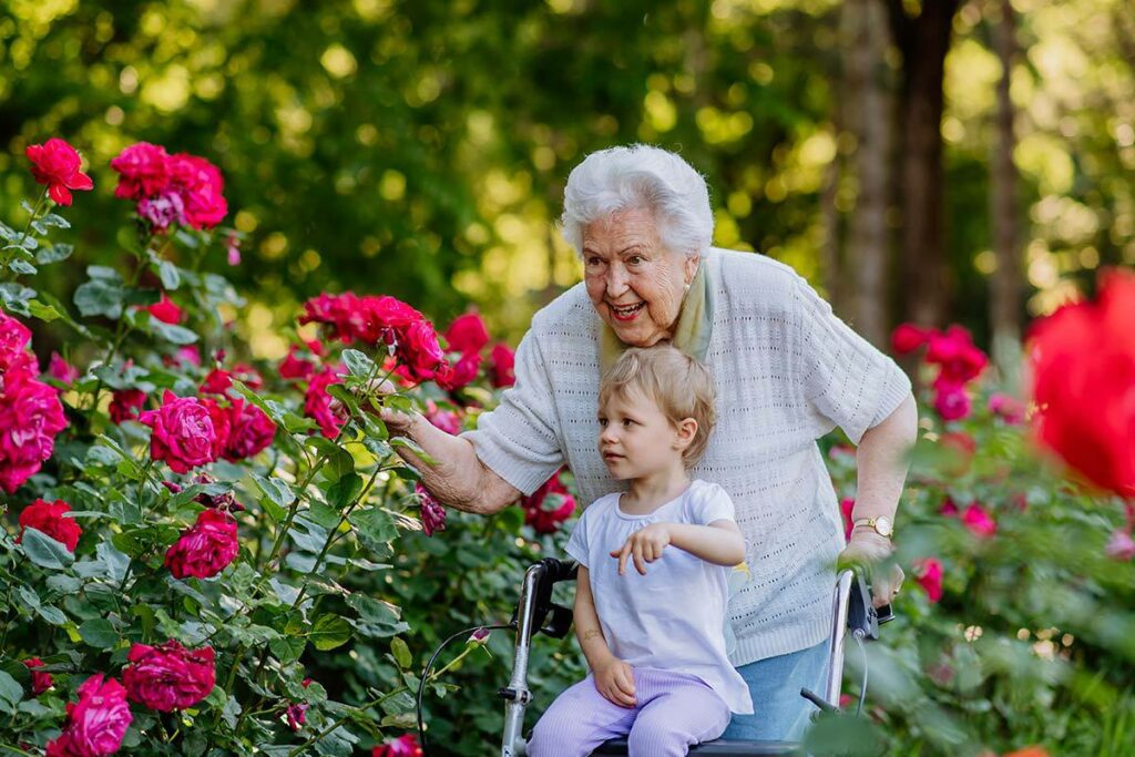 South Hill Village | Happy senior woman with visiting child looking at flowers outside