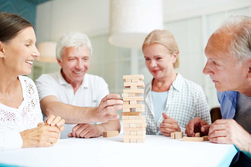 Laketown Village | Group of seniors enjoying assisted living and memory care near Metarie, Louisiana. Playing a game of Jenga.