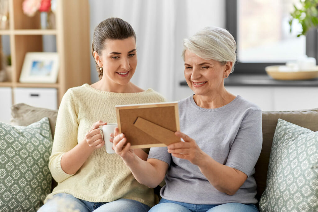 Broadway Mesa Village | Senior woman and her daughter looking at a picture in a frame