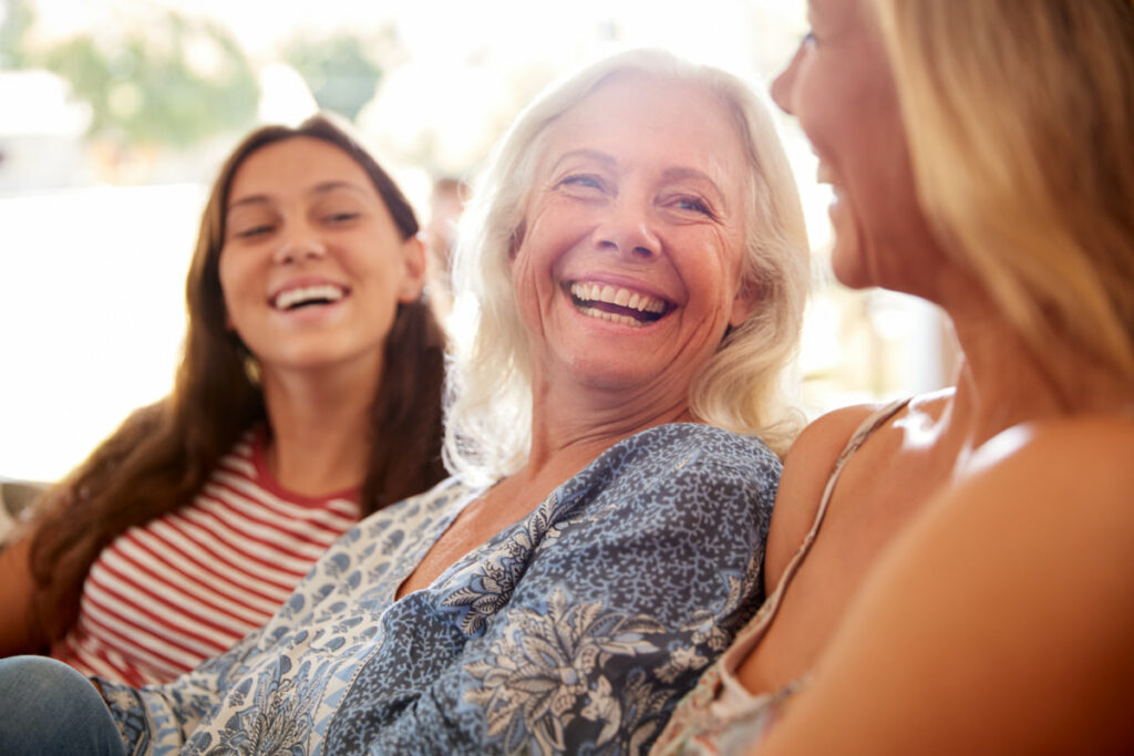 Historic Roswell Place | Senior lady laughing on the sofa with her daughters