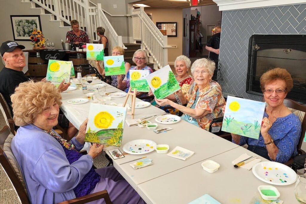 Creston Village | Senior showing off their paintings